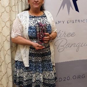 Natalie Ritchie smiles a for picture with her vase at the 2023 Retiree Banquet